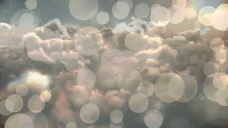 animación de manchas bokeh blancas de luces de navidad sobre un cielo nublado