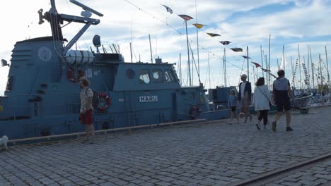 boat on a dock with people and flags
