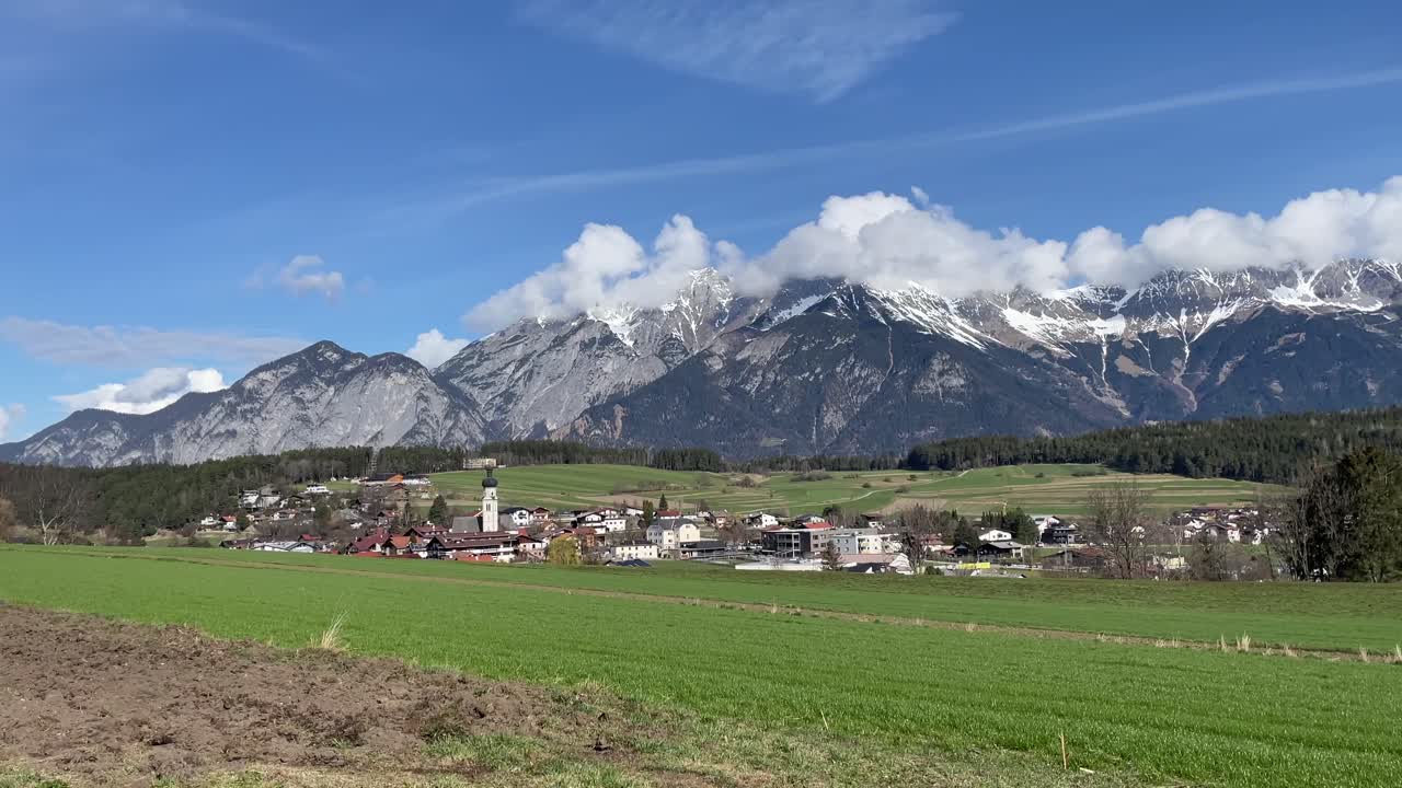 Scenic spring view of Mutters, Tyrol with dramatic snowy peaks.