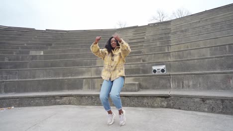 smiling black woman dancing on steps in park