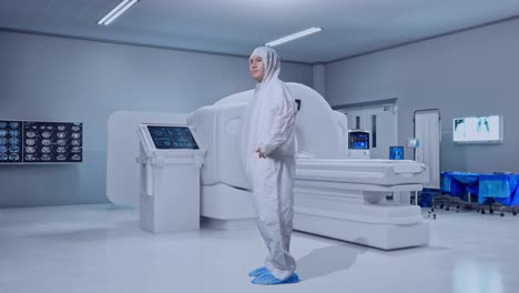 full body side view of asian male scientist putting hands on his hip and looking around with mri machine in the hospital