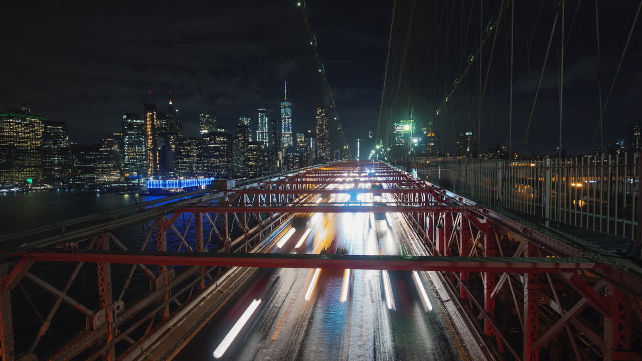 coches de tráfico sobre el puente de brooklyn contra el telón de fondo de la silueta de la noche en nueva york