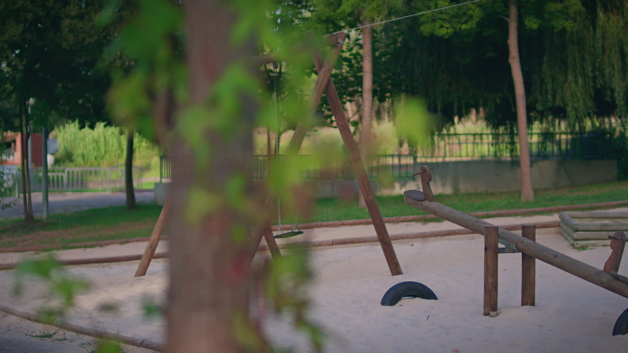 patio de recreo para niños sin gente columpio de madera cámara lenta tiro largo