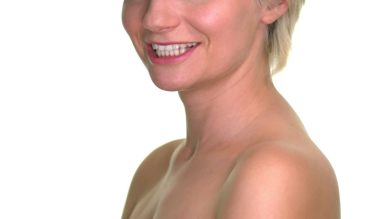 primer plano de la mitad de la cara de una mujer y la mitad de su torso, riendo e inclinando la cabeza hacia atrás sobre un fondo de estudio blanco sin costuras