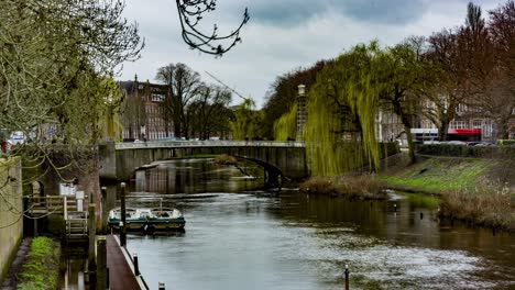 Wide-Time-lapse-of-people-and-cars-crossing-bridge-over-river-in-Den-Bosch,-the-Netherlands