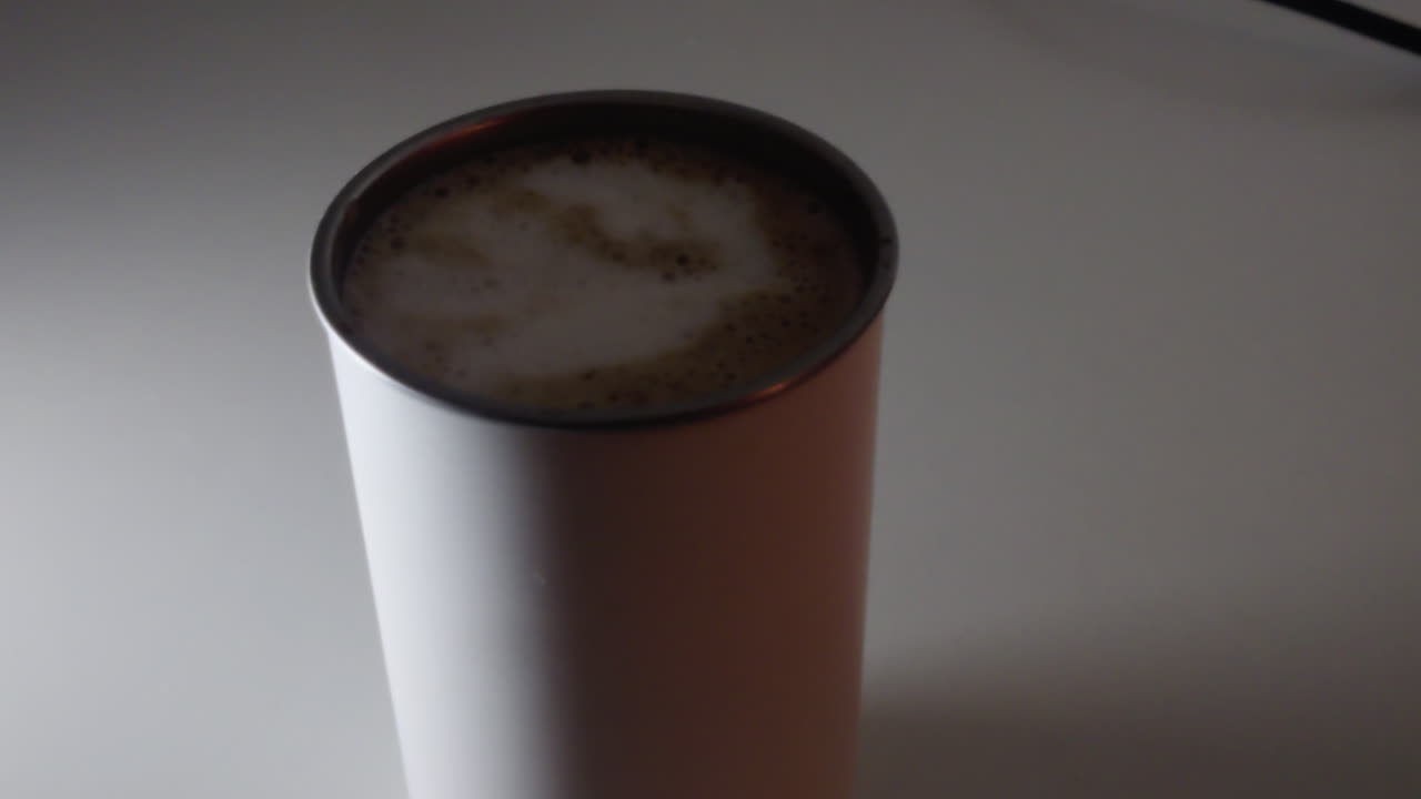 Smooth dolly-in shot of a coffee in a white cup. Natural color grade and sharp textures in a 2026 style