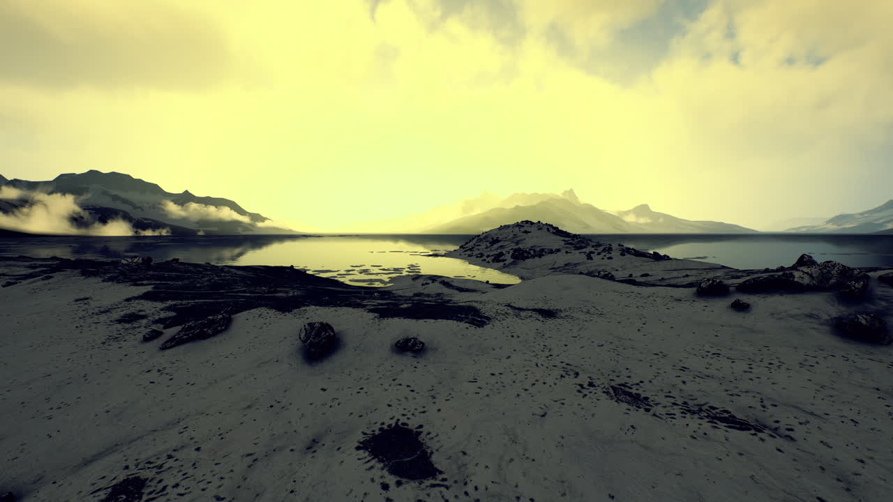 Dramatic landscape featuring serene water and distant mountains at dawn
