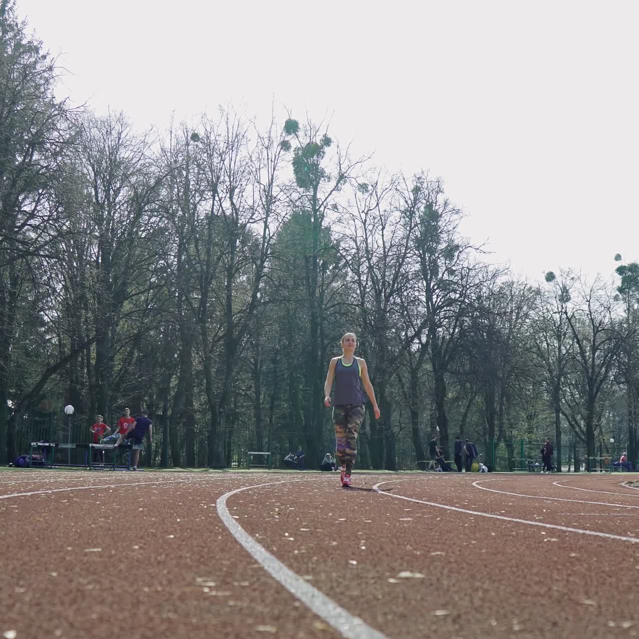 Track runner athlete woman warming up before running at a stadium. Sport. Healthy fitness lifestyle.