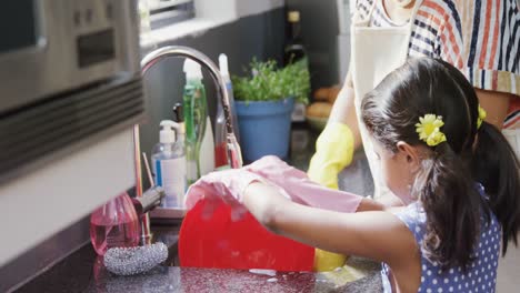 Grandmother-and-granddaughter-washing-dishes-in-the-sink-4K-4k