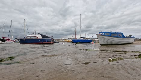 cloudy day with boats on sandy shore