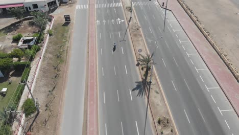 Toma-Aérea-De-Un-Coche-Y-Una-Moto-Circulando-Por-La-Autopista-De-Gawadar-Baluchistán