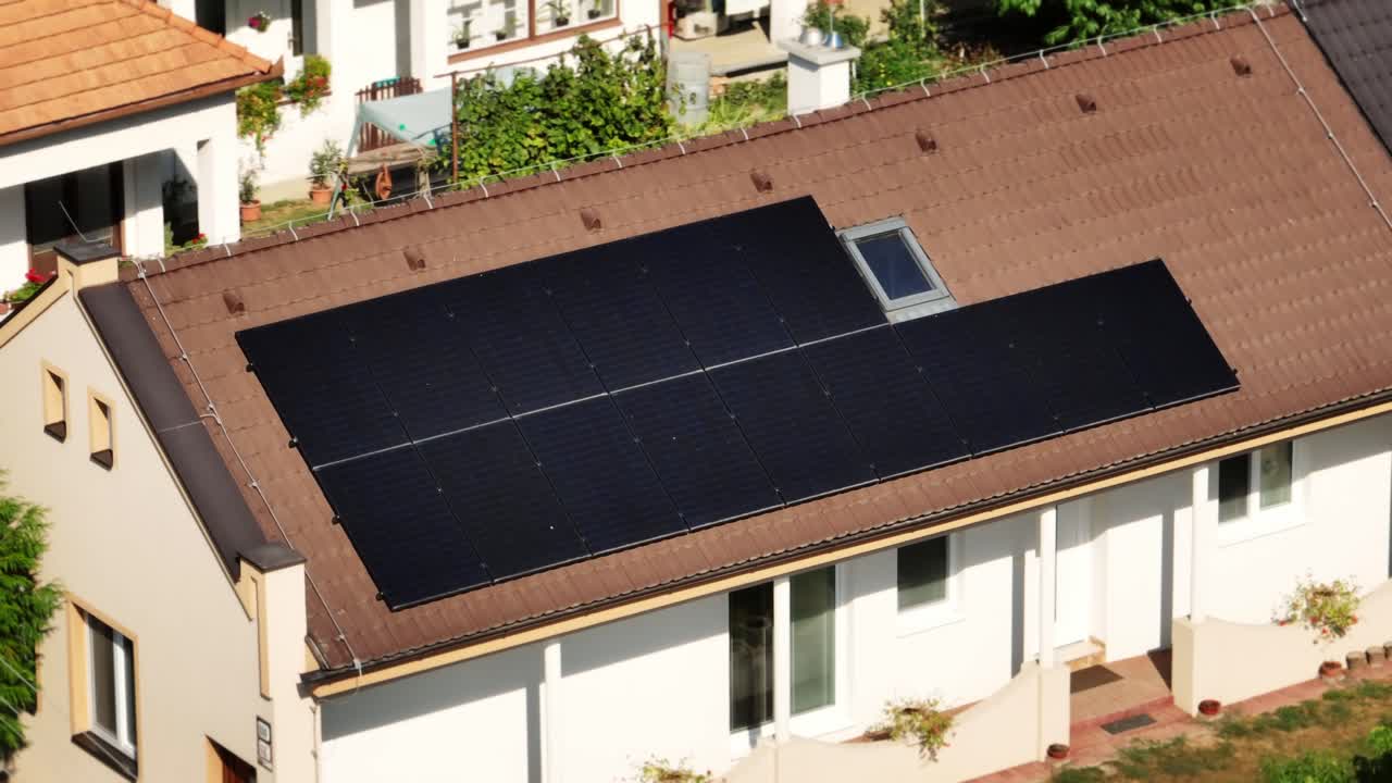 주거 지붕에 설치된 태양 전지판의 공중 사진으로 집의 지속 가능한 에너지 솔루션과 재생 가능한 에너지에 대한 헌신을 보여줍니다.