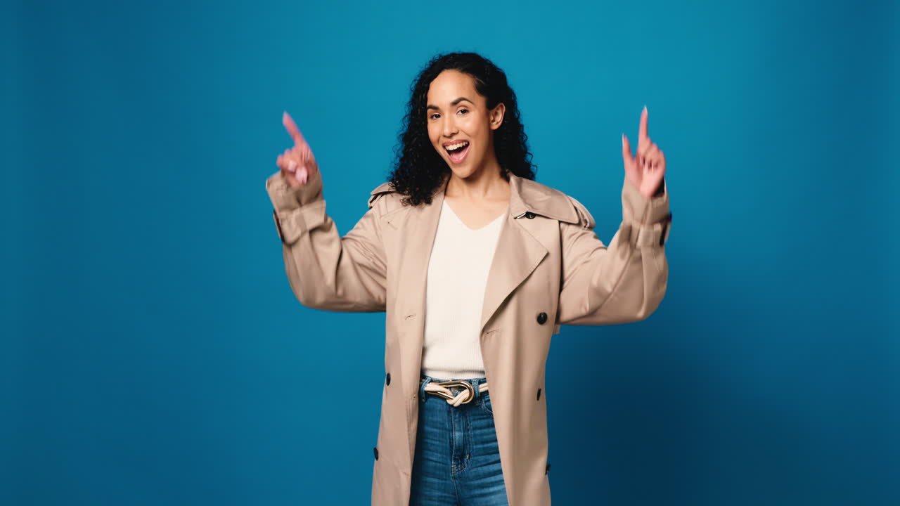 Woman in trench coat pointing upwards