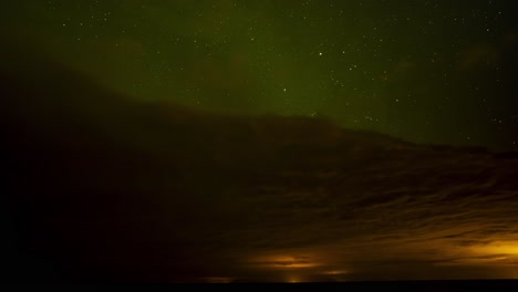 Hermoso-Lapso-De-Tiempo-De-Auroras-Boreales-Verdes-Sobre-Nubes-Oscuras-Con-Un-Cielo-Nocturno-Estrellado-Con-Estrellas-Fugaces