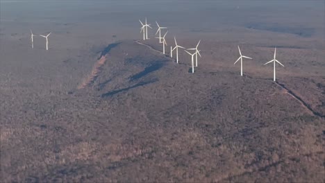 green power wind turbine windmill energy electric generation high angle distant pov airplane aerial drone telephoto cinematic view