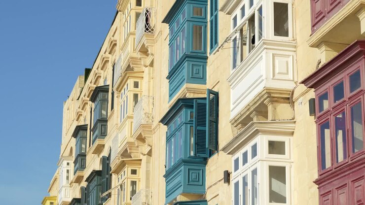 Janelas e persianas coloridas em edifícios de calcário em Valeta, Malta.