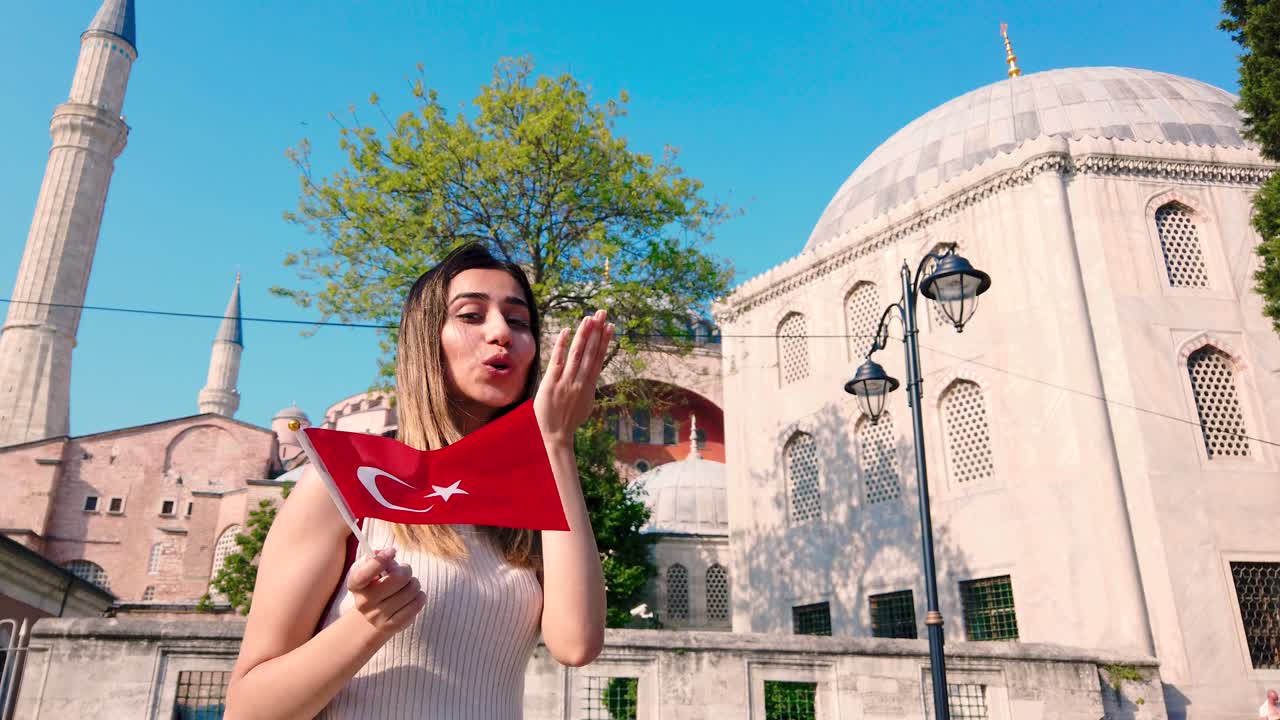 cámara lenta: hermosas chicas jóvenes ondean la bandera turca frente a un edificio antiguo en estambul, turquía, concepto de viaje