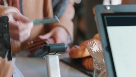 close up customer paying using credit card contactless payment spending money in cafe with digital transaction service