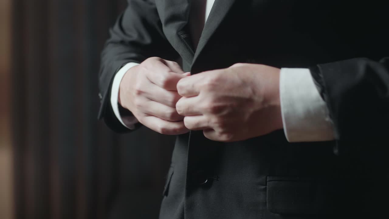 el hombre abotonando su chaqueta de traje