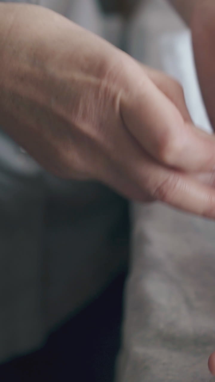 infant boy in white diaper lies on baby changing table and skilled nurse performs hypertonus legs foot massage closeup