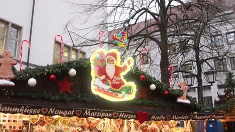 signo de neón de papá noel en un trineo en una tienda tradicional de dulces en heidelberg, alemania en un festivo mercado de navidad en europa
