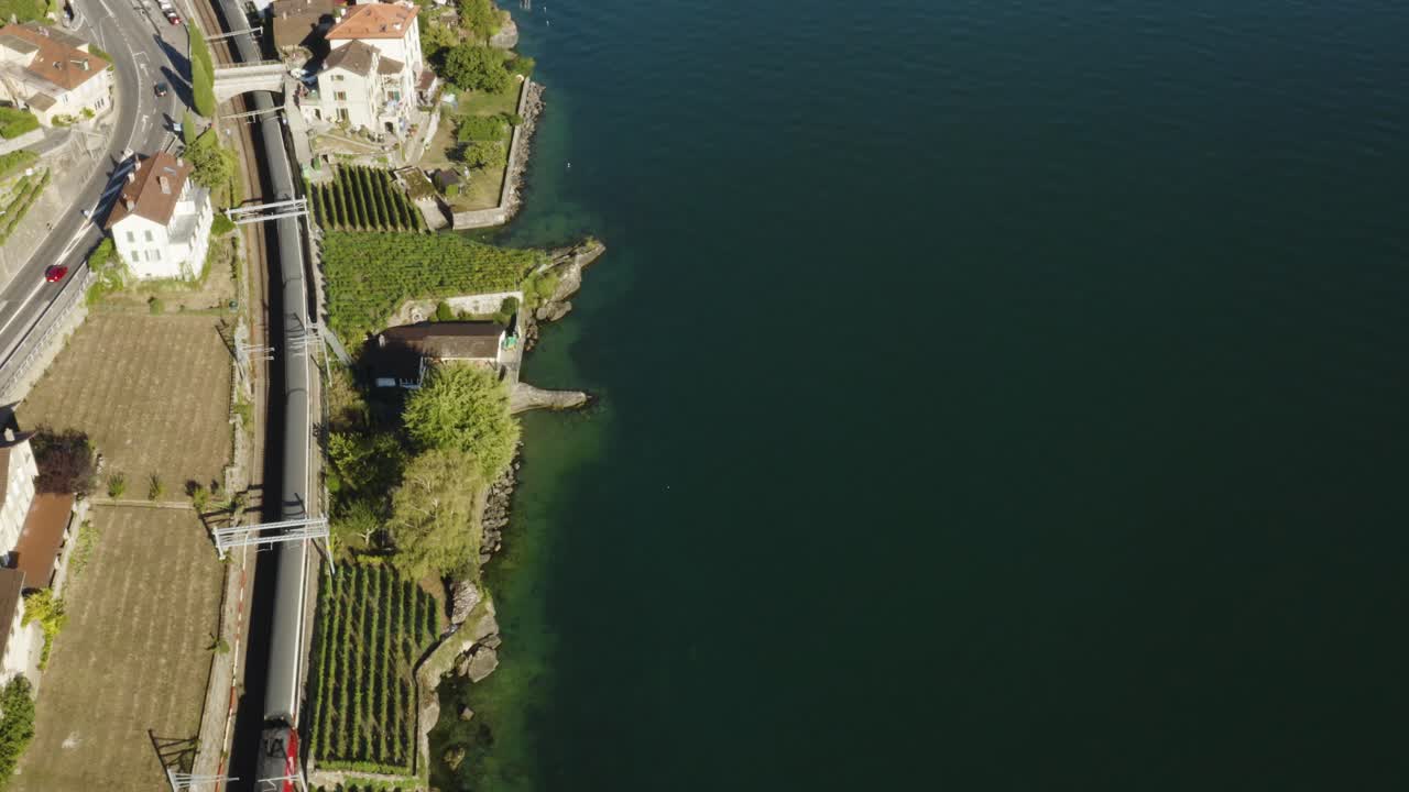 Vista aerea dall'alto di un treno svizzero che passa lungo la riva del Lago di Ginevra nei vigneti di Lavaux.