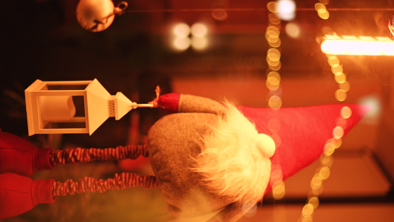 Close up of decorations on a lighted Christmas tree. Vertical