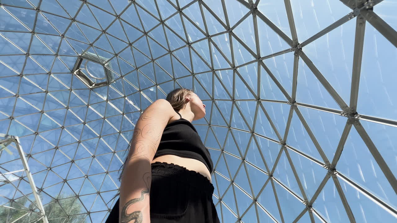 A young beautiful woman stands within an ethereal geodesic dome, surrounded by mystical geometry and cosmic energy, embodying spiritual awakening, introspection, and transcendental harmony.