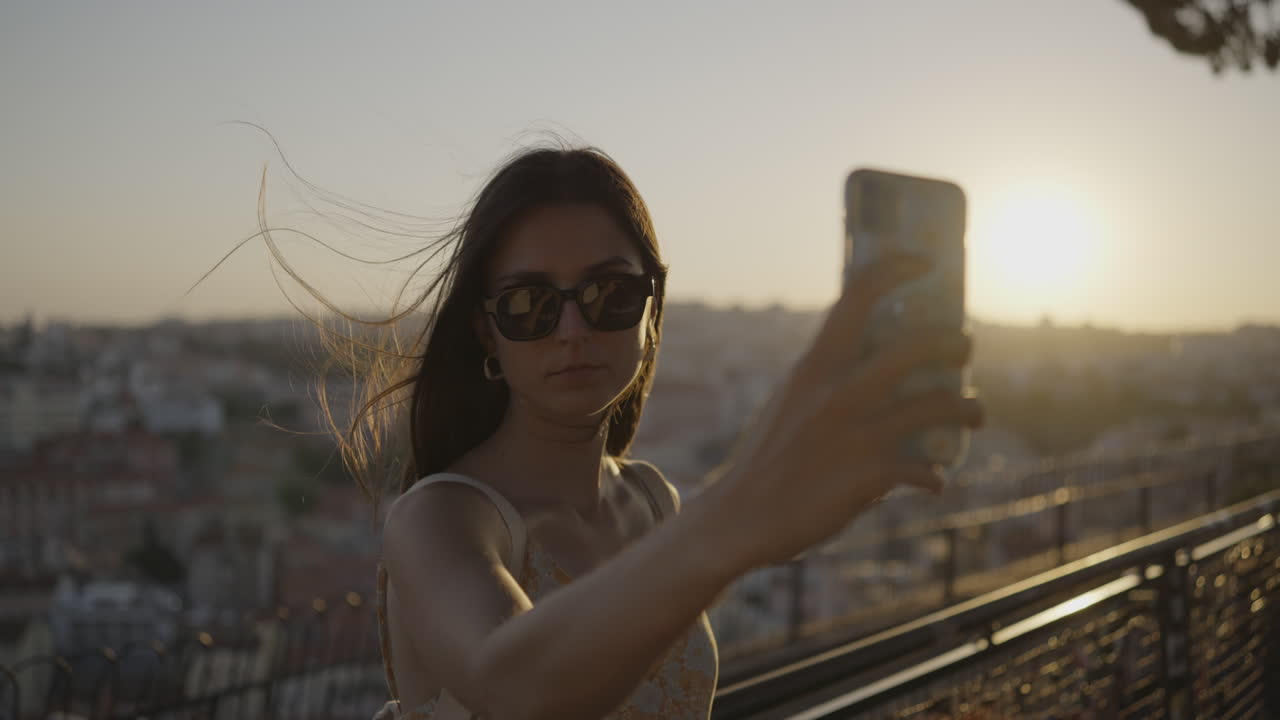 Woman Taking Selfie at Sunset Over City