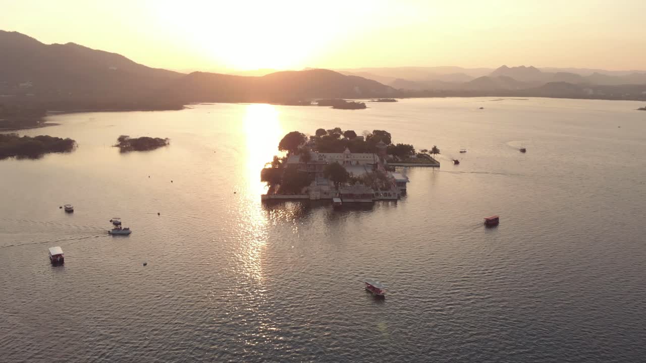 imágenes aéreas de 4k del palacio del lago taj al atardecer en la ciudad junto al lago de udaipur, india