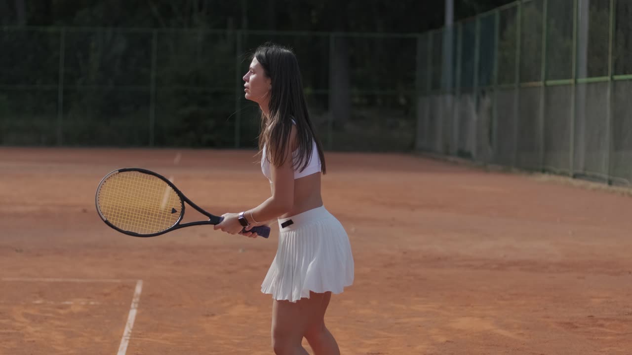 아름다운 테니스 소녀가 야외 코트에서 을 연습하고 있습니다.