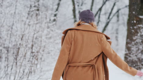 mujer feliz disfruta de un paseo en el parque de invierno