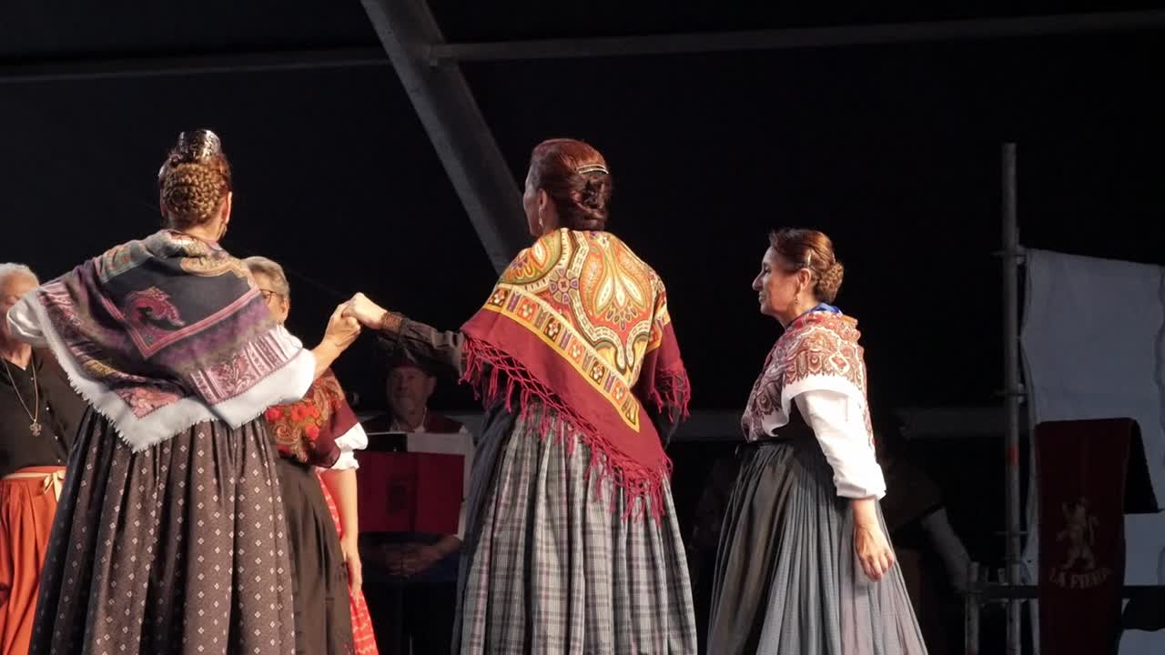 Women in traditional dresses perform a folk dance during El Pilar celebrations in Spain