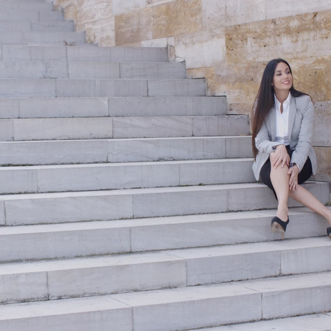 mujer de negocios sentada con las piernas cruzadas