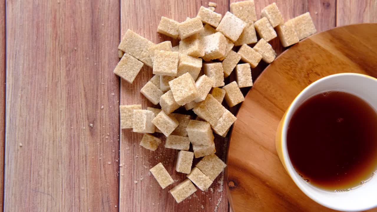 cubos de azúcar marrón y una taza de té