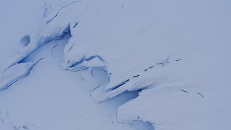 Aerial-of-glacier-ice-covered-in-white-snow-in-Alaska-looking-like-frozen-waves