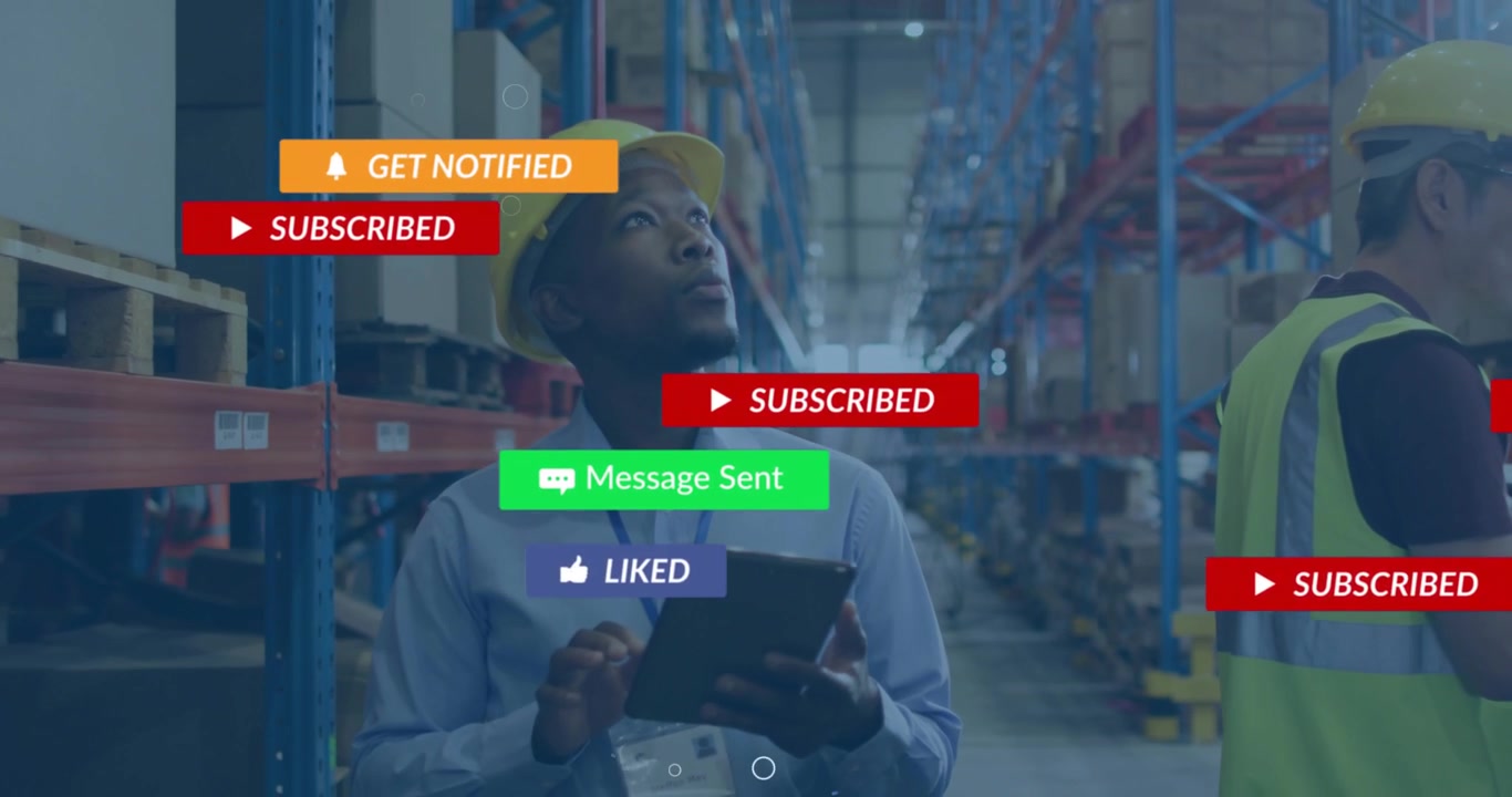 Warehouse worker scrolling tablet displaying notifications floating while coworker typing laptop