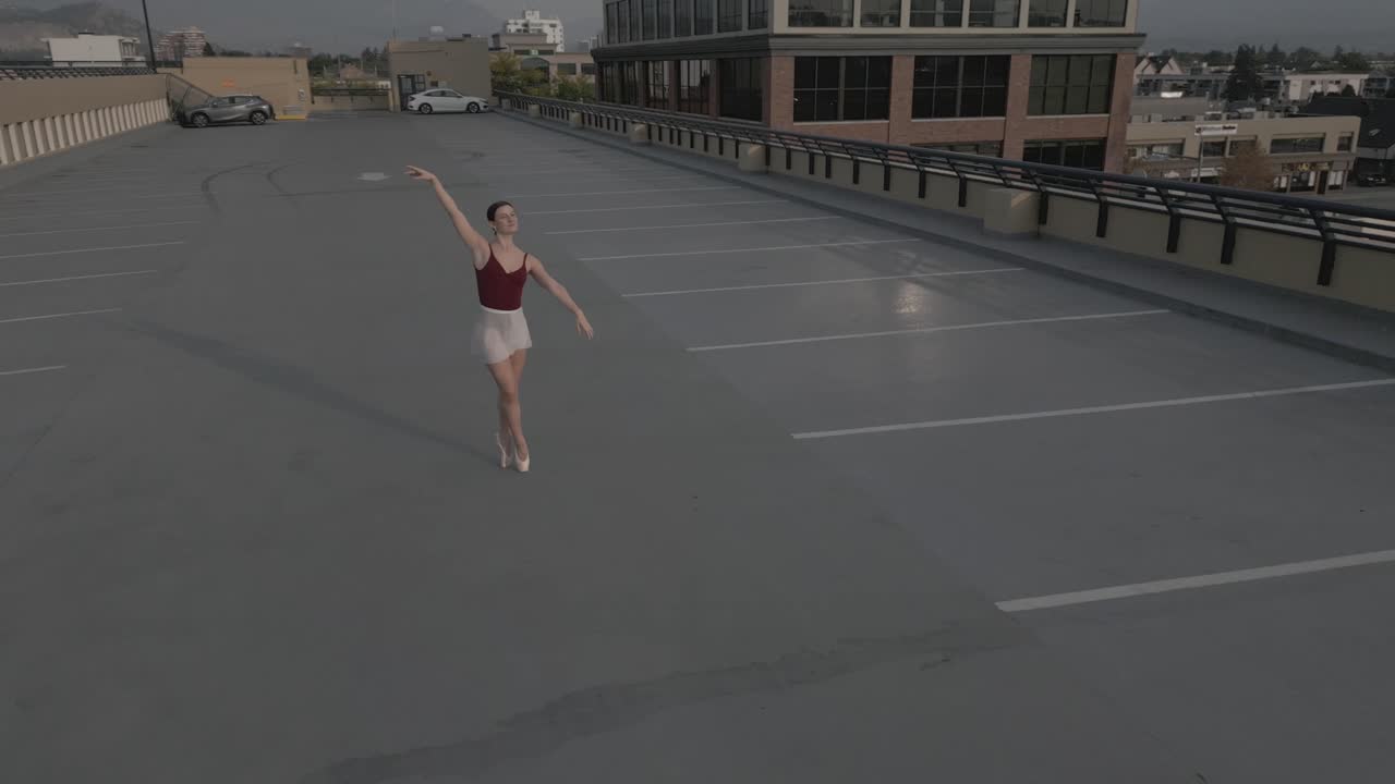 volando lejos de una bailarina de ballet en un estacionamiento en la azotea