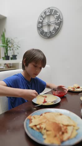 boy eating pancakes at home