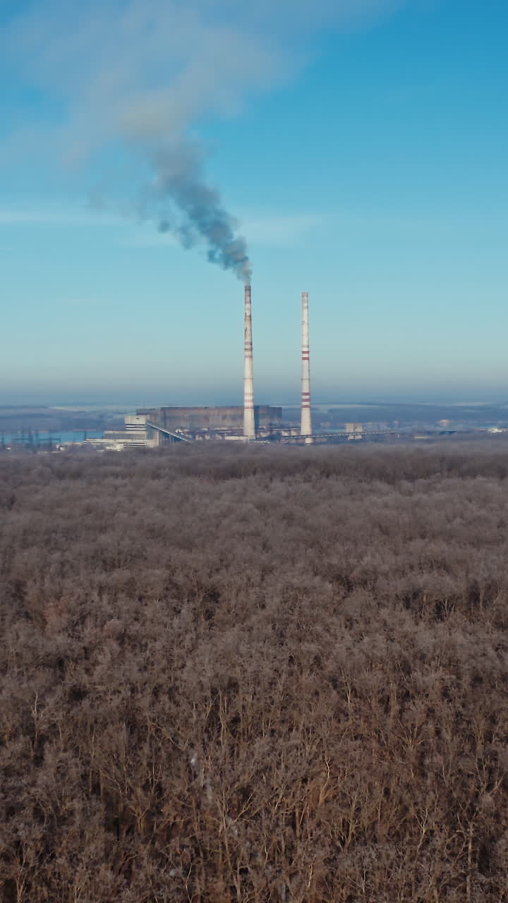 Landscape with smoked polluted atmosphere. Aerial view of high chimney pipes with grey smoke