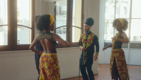man and woman practicing tango steps in front of the mirror at dance studio