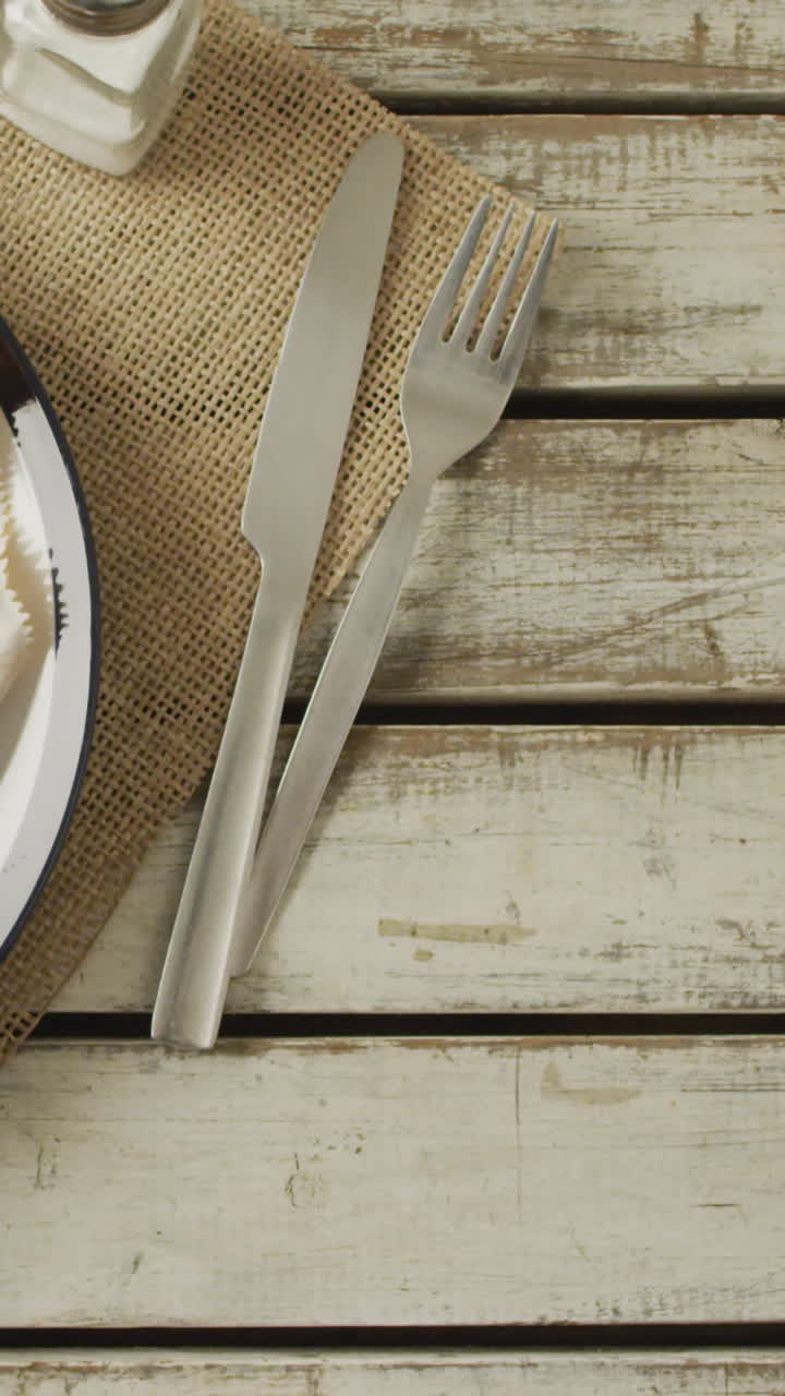 video de pescado y papas fritas en un plato, sal y pimienta y ketchup, con espacio de copia en la mesa de madera