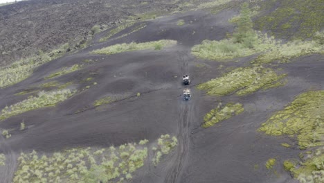monte batur en bali indonesia pared lateral cubierta de ceniza escalada por dos vehículos todo terreno, toma de seguimiento de vehículos aéreos