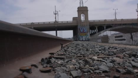 Looking-down-the-rail-on-an-empty-train-track-toward-a-bridge-going-over-the-LA-river-in-Los-Angeles