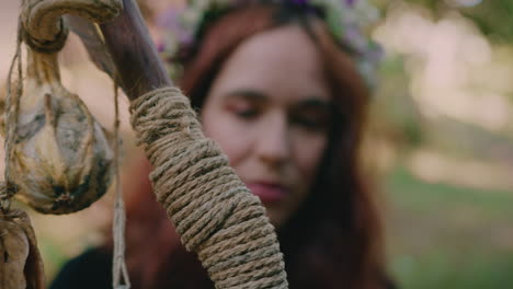 chica joven sosteniendo su bastón druida en un tiro de cerca del bosque