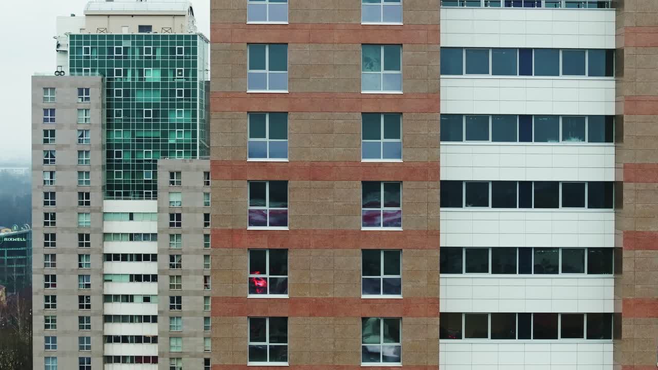 Plano cinematográfico de drone deprimente circulando edifícios altos em uma cidade monótona