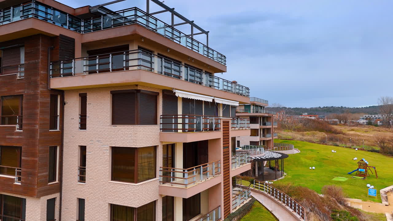 Moderne bygninger i et boligområde. Tre etagebygninger står i et roligt kvarter under en overskyet himmel. Arkitekturen er enkel med altaner