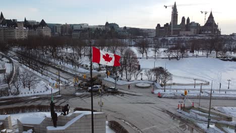 canadian flag in front of excavator due to protests against government measures taken by police, canadian flag in foreground - ottawa, ontario