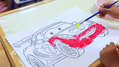 close-up 4k video of a child painting a cartoon race car. ideal for educational, art, or creativity-themed content. vibrant, playful, and perfect for school or early childhood visuals.
