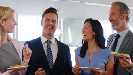cuatro personas sonrientes sosteniendo su plato